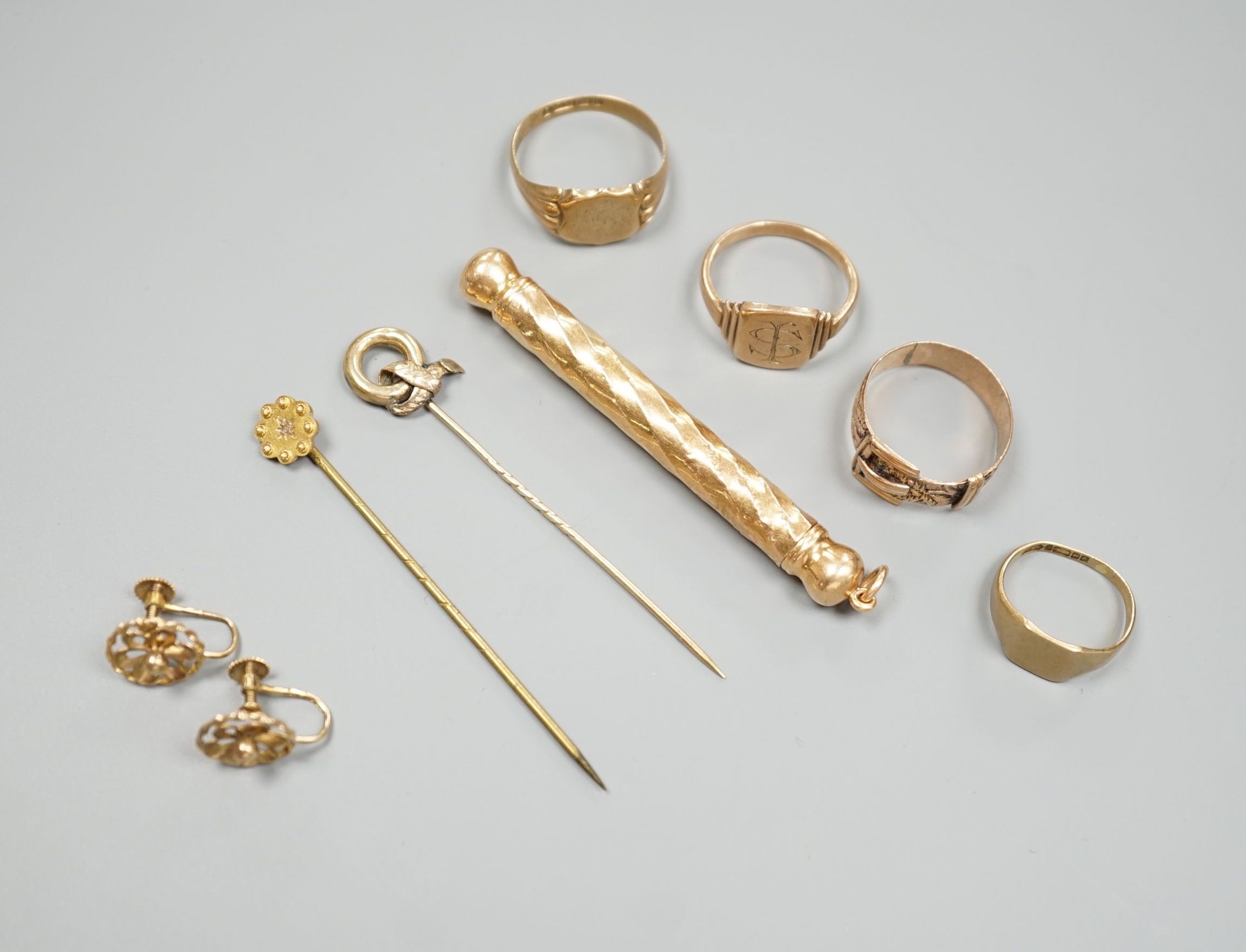 Four assorted 9ct rings including a Victorian buckle ring, 14 grams, two stick pins including part 15ct, a pair of yellow metal ear clips and a yellow metal overlaid propelling pencil.
